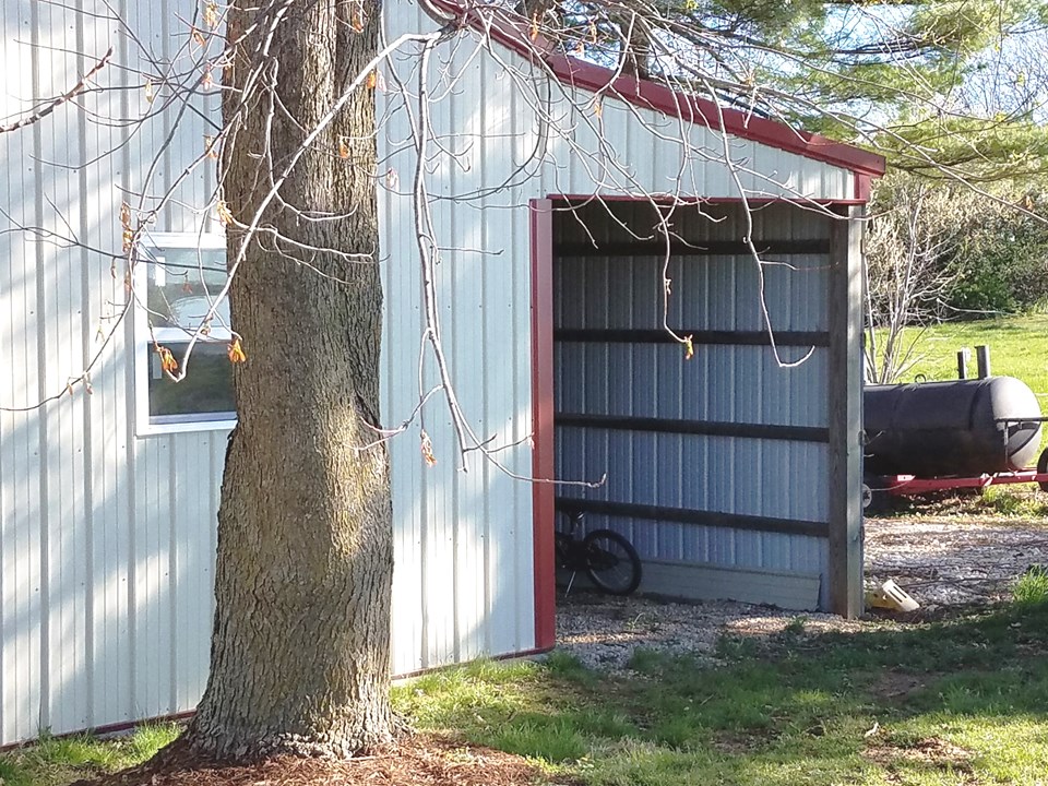 covered lean-to attached to the back of the outbuilding adds more storage.