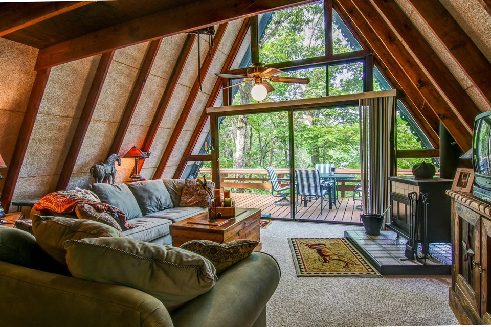 great room with wood-burning stove and rear wall of windows.